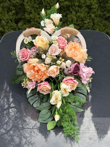 Kompozycja w drewnianym sercu w delikatnych kolorach